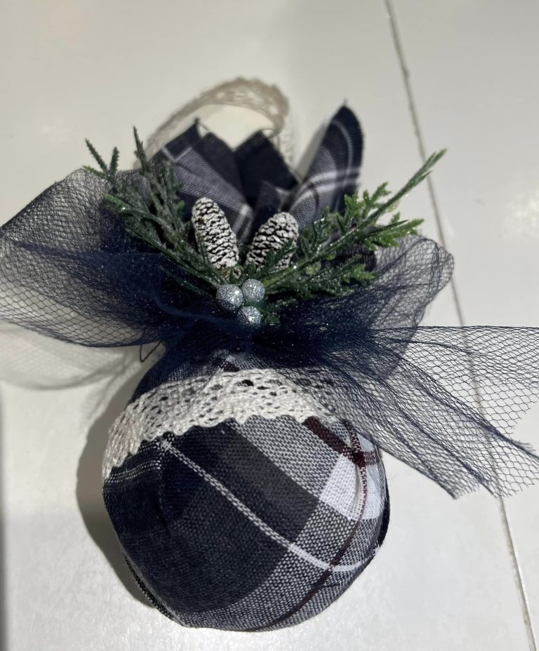 A styrofoam ball wrapped in some black-and-white fabric and tied off with a ribbon at the top.