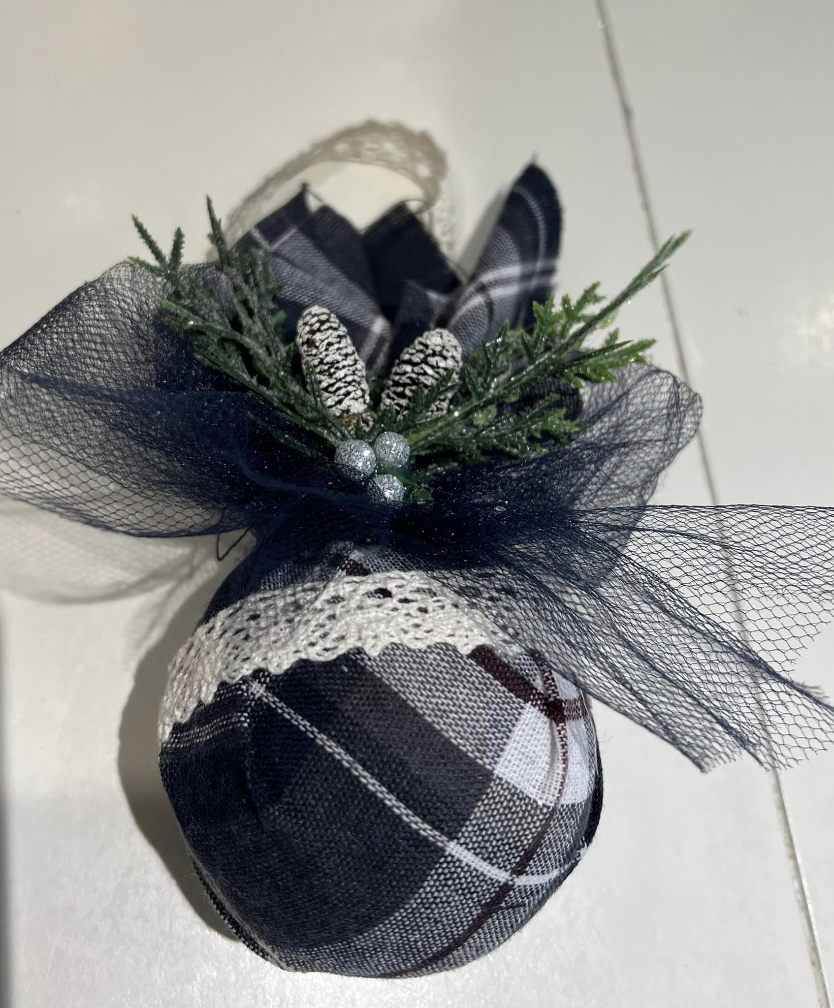 An ornament of a ball wrapped in some black-and-white fabric.