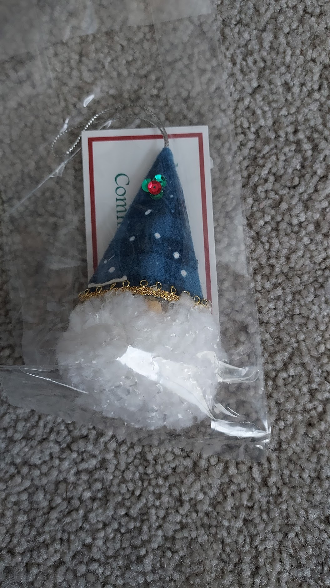 A gnome ornament made with a pom-pom and fabric cone hat.