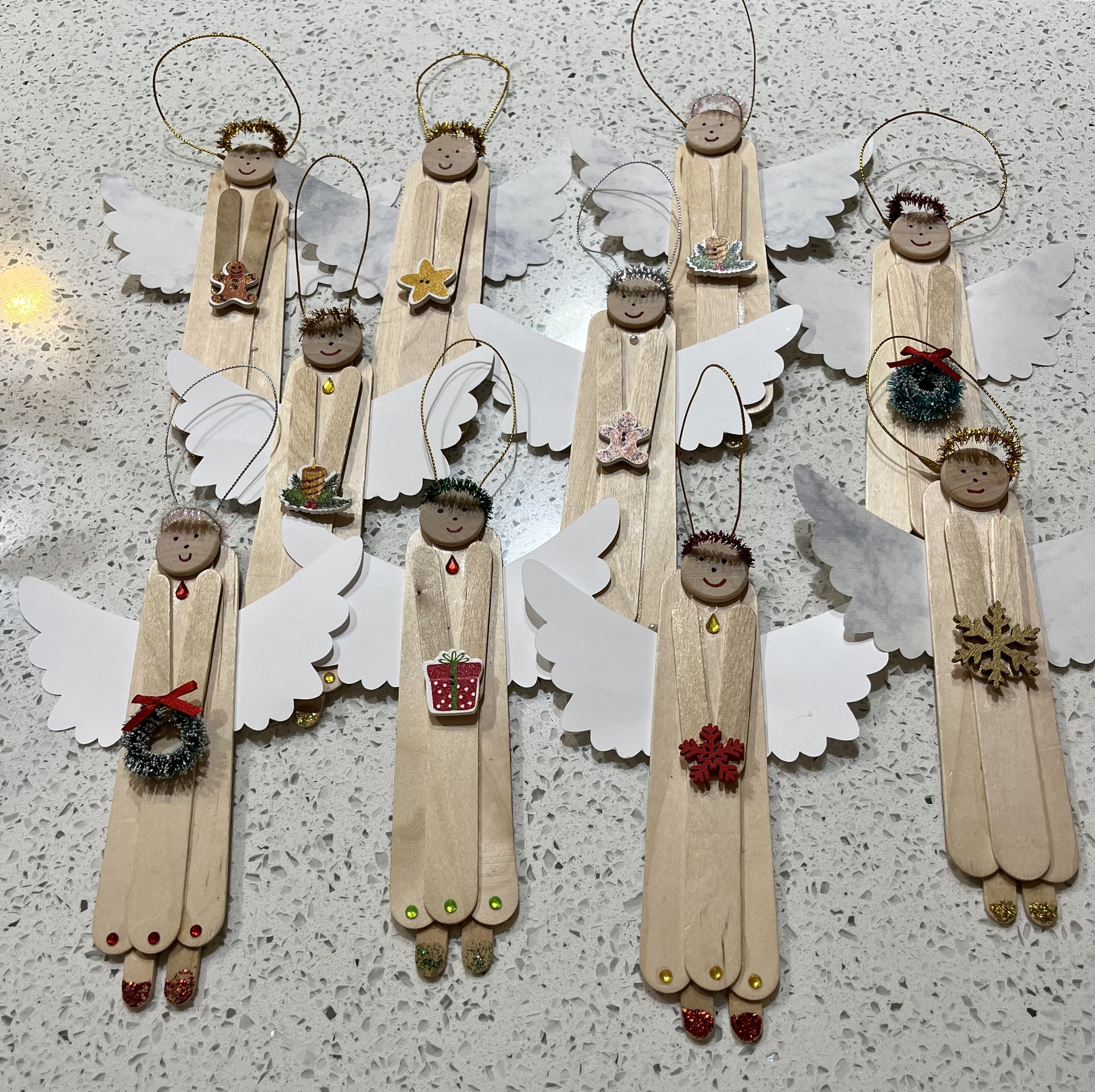 An ornament made from popsicle sticks made to look like angels.