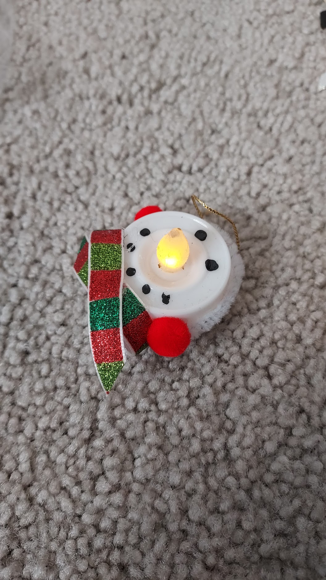 A battery-powered tea light made to look like a snowman.