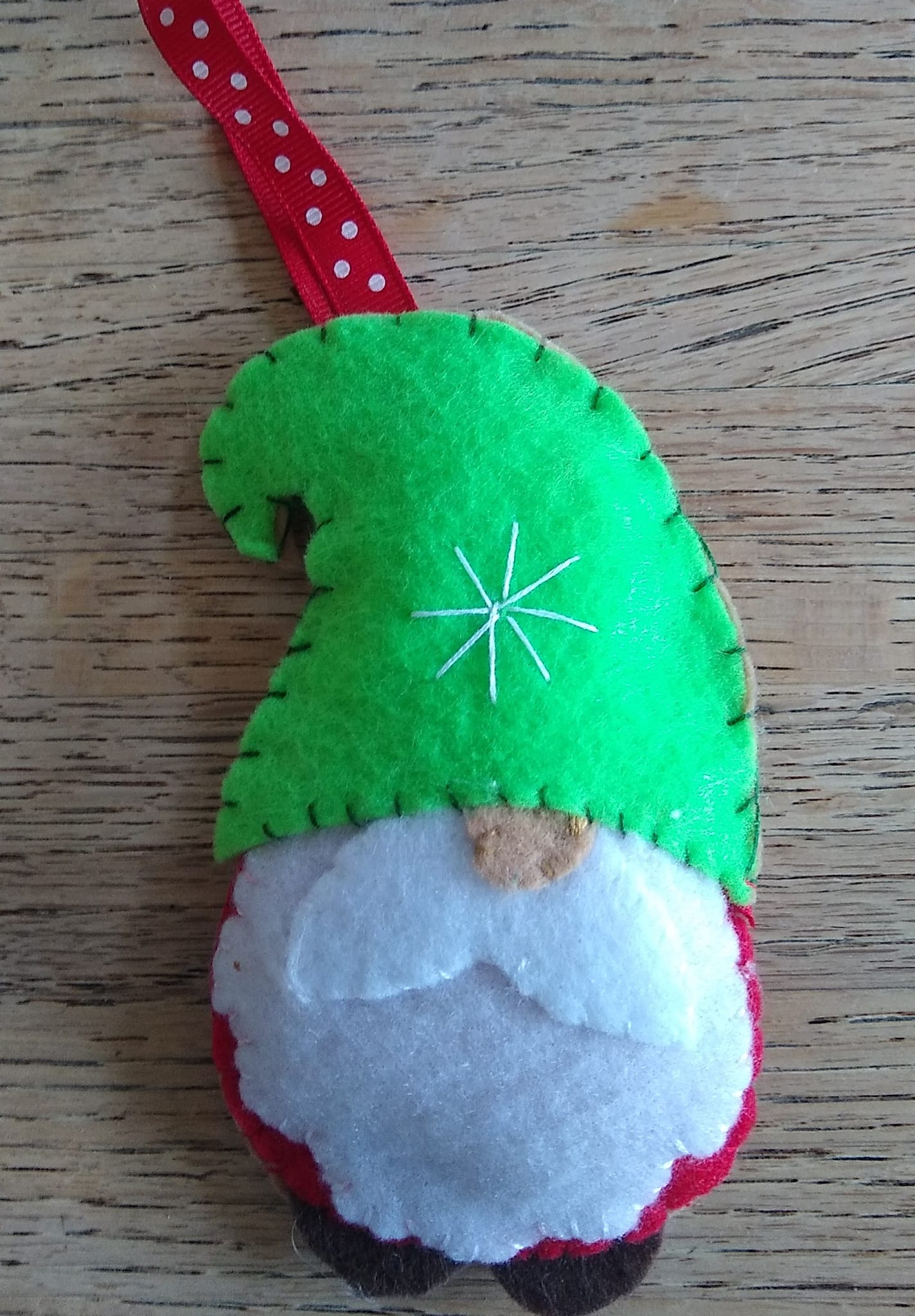 A felt-stitched gnome ornament with a green hat.