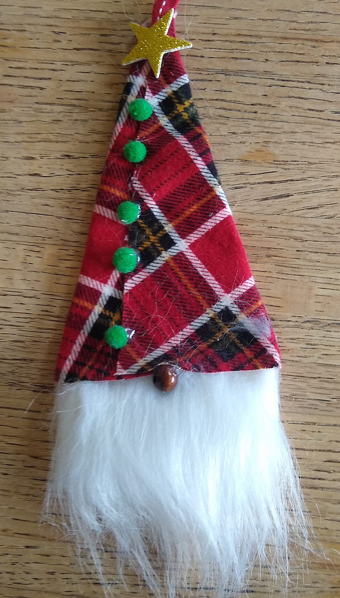 A cone of fabric glued or sewn together to look like a gnome hat with faux hair coming out the bottom to look like a beard. A red bead acts as the gnome's nose.