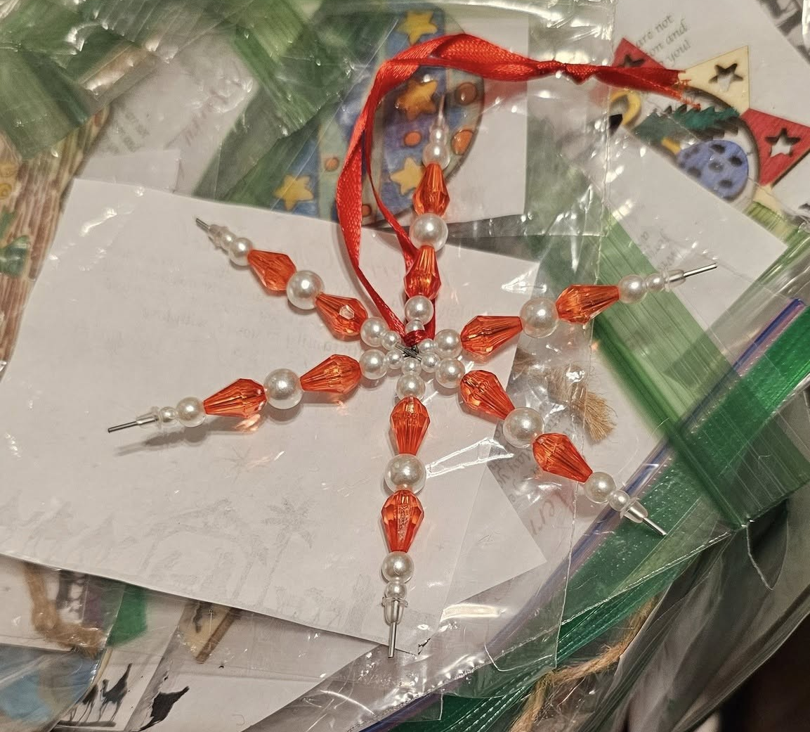 A candy cane made from clear and red beads.