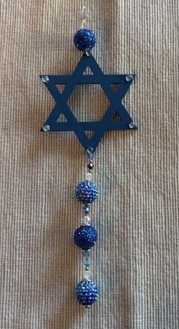 A blue star of David hanging decoration with iridescent blue and azure beads hanging from the bottom of it.