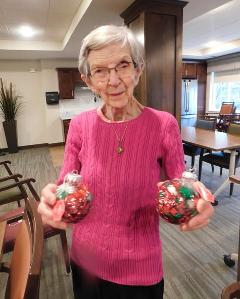 A senior woman holding a handmade ornament.